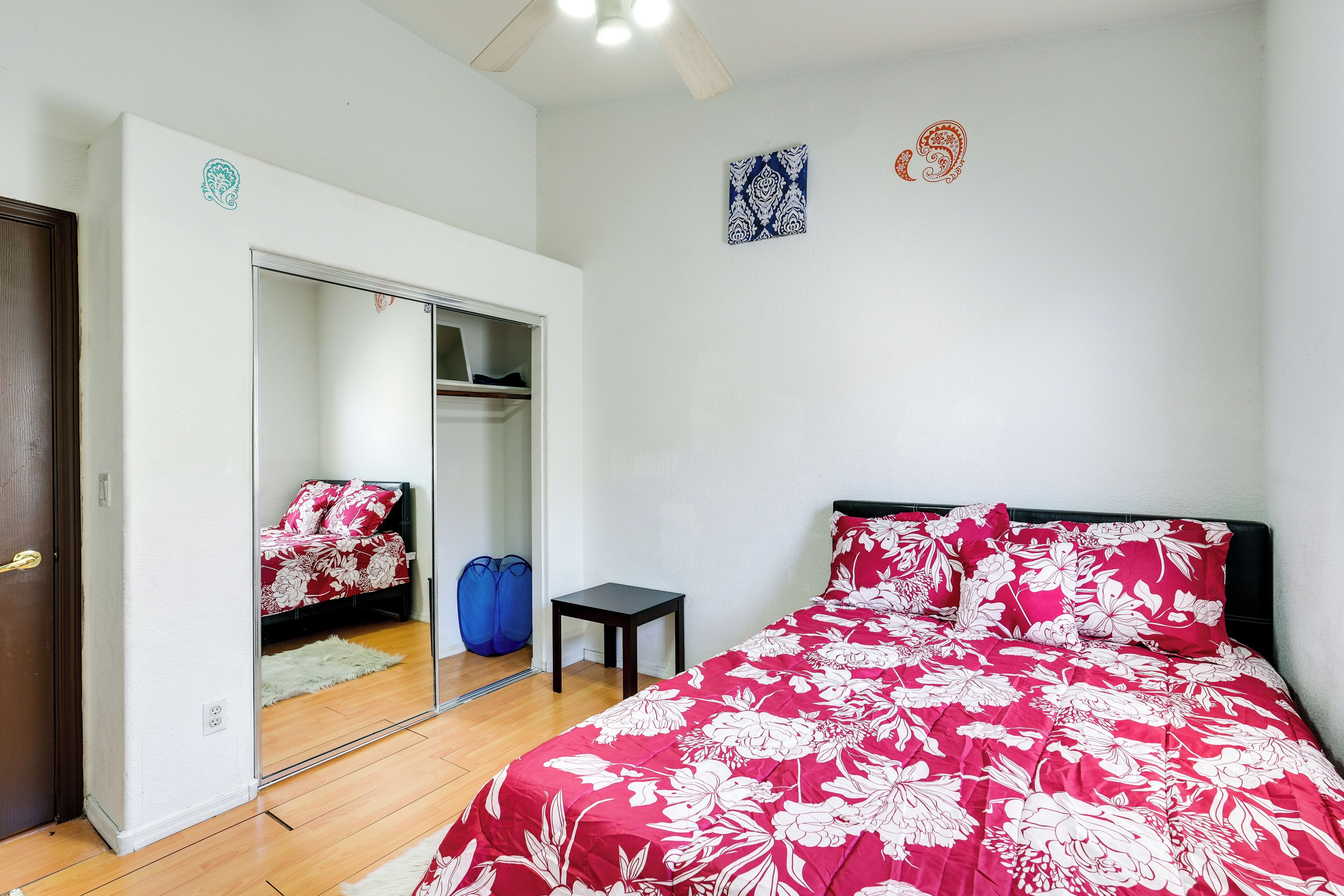 Une chambre à coucher avec un lit, une armoire, une petite table et un miroir.