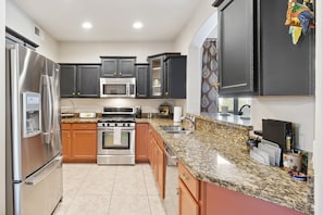 Enjoy cooking in this well-equipped kitchen with oven, microwave, and double sink.