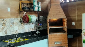 Een koelkast, een kookplaat, een blender, kookgerei, borden en bestek