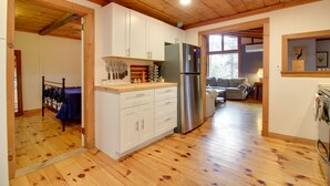A kitchen with wooden floors, a refrigerator, and cabinets. - Weston Vacation Rental - Close to Ski Resorts! (Weston)