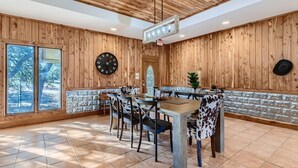 A dining area with a wooden wall, a clock, and a large window. - Hidden Valley: Your Dream Rustic Wedding Venue w/t Complimentary Accommodations (Austin)