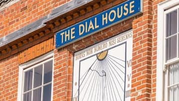 A building with a sign reading "The Dial House" and a large clock with Roman numerals.