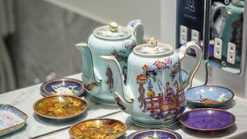 A collection of ceramic tea sets and bowls on a marble countertop.