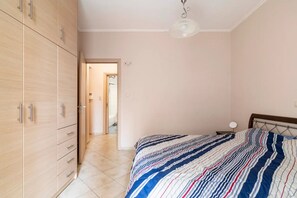 A bedroom with a bed, a wardrobe, and a door leading to another room. - "whole House in Kolonos, Centre of Athens" (Athens)