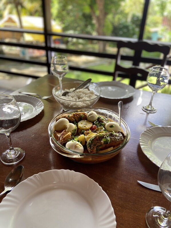 A dining table with a meal, wine glasses, and a bowl of rice. - Pousada La Maison Du Baron  (Alcantara)