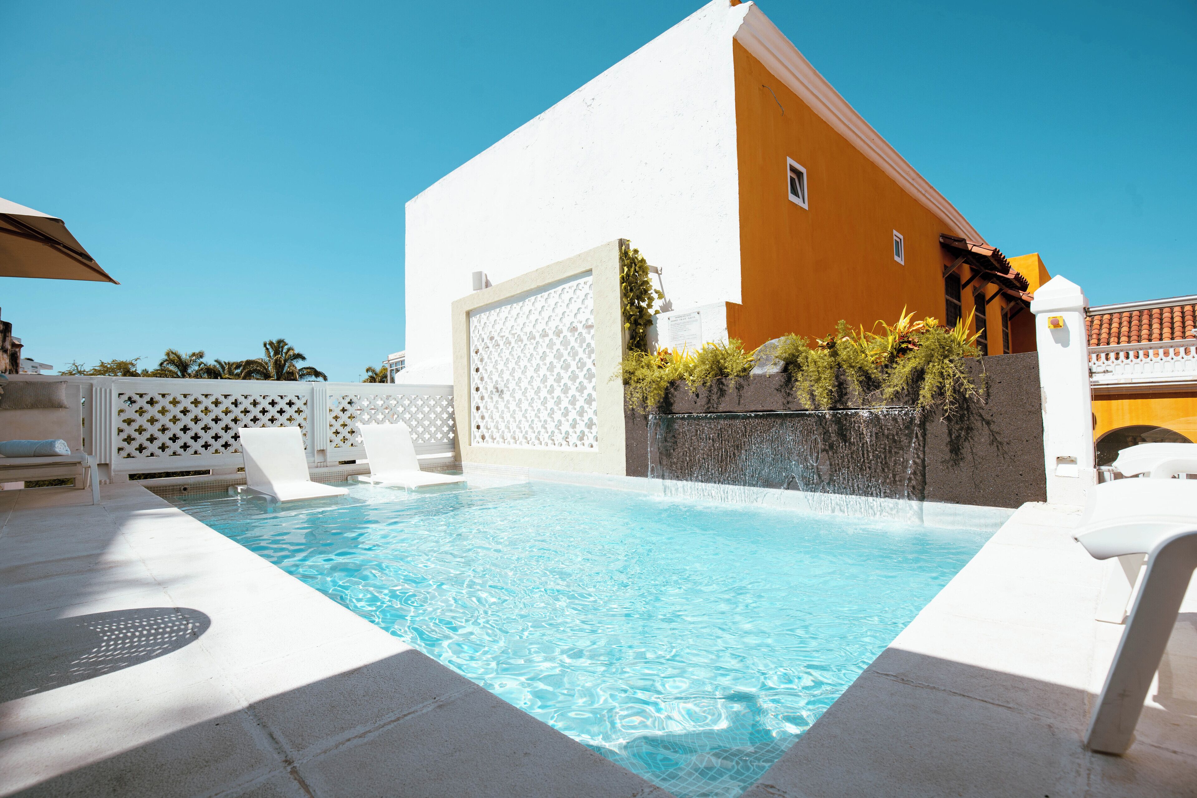 Een buitenzwembad, parasols bij het zwembad en ligstoelen