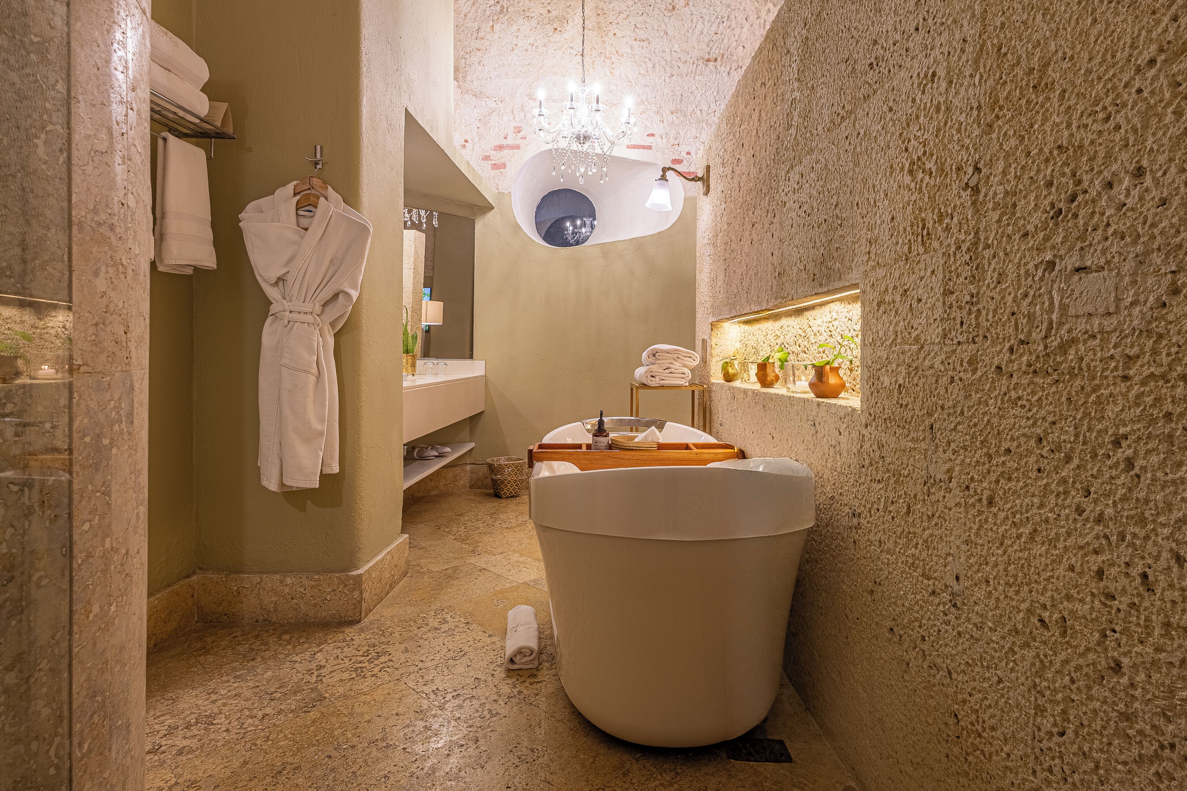 Un baño estrecho con una bañera, un perchero para toallas y un espejo.