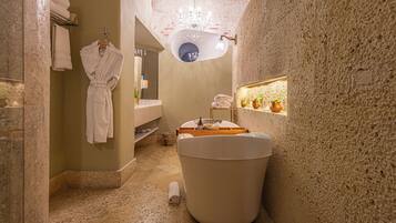 Un baño estrecho con una bañera, un perchero para toallas y un espejo.