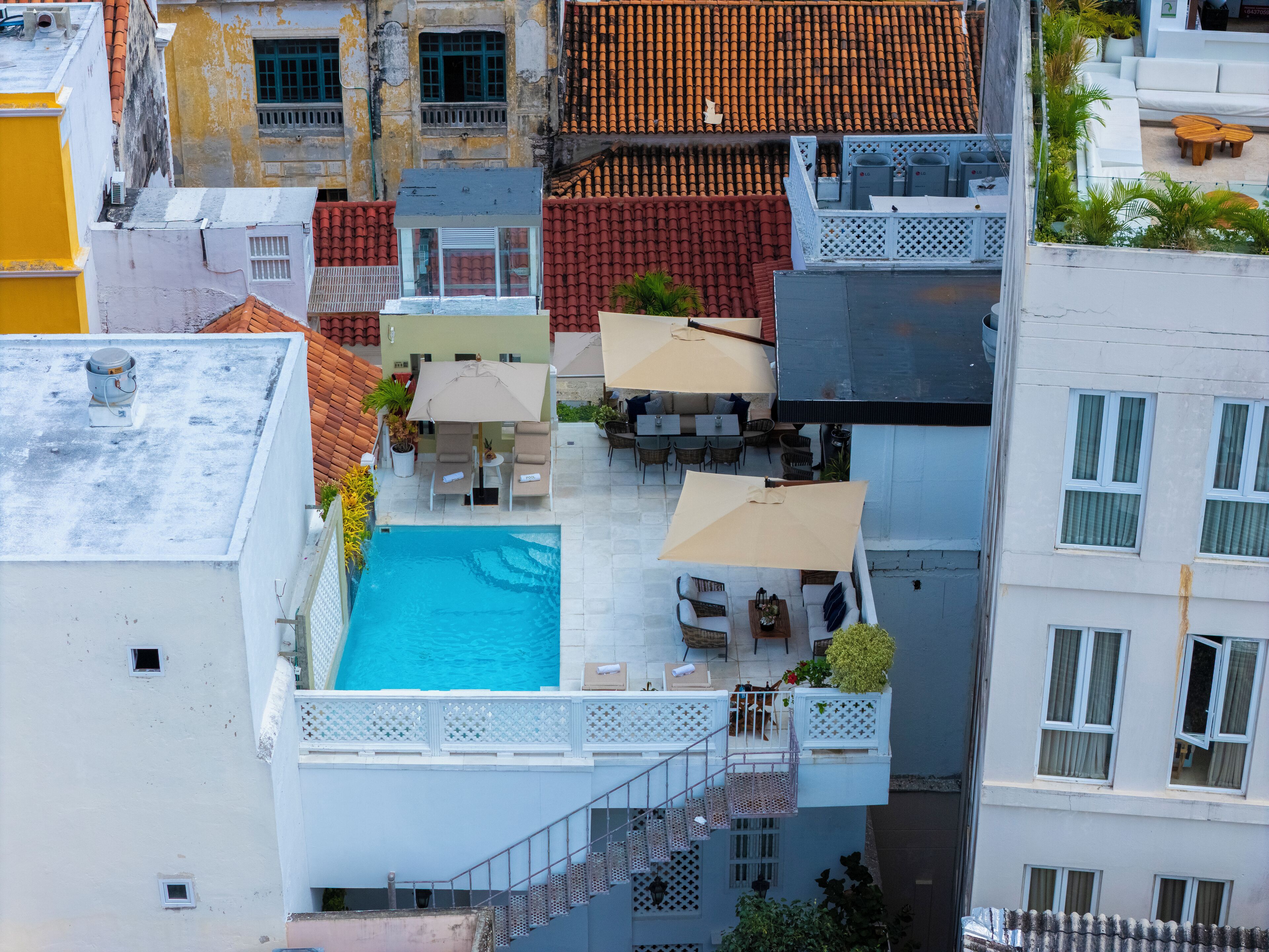 A rooftop pool area with multiple seating arrangements and a small pool.