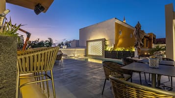 Una piscina al aire libre, sombrillas, sillones reclinables de piscina