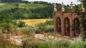 A brick building with arched windows and a garden with a fountain. - Private Villa with WIFI, A/C, private pool, hot tub, sauna, TV, veranda, close to Montepulciano (Bivio Di San Biagio)