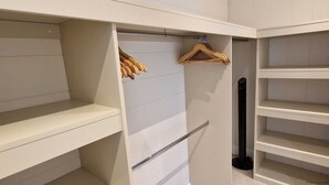 A walk-in closet with open shelves and wooden hangers. - Elderberry Lodge | sleeps 4 - Hot Tub, Dog Friendly - 5* Gold Award (Pickering)