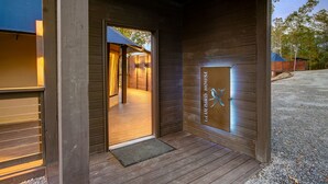 A wooden exterior with a door leading to a room. - The Covey an African Tent Retreat Bluebird House (Garland County)