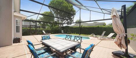 An outdoor patio with a pool, surrounded by a glass enclosure.