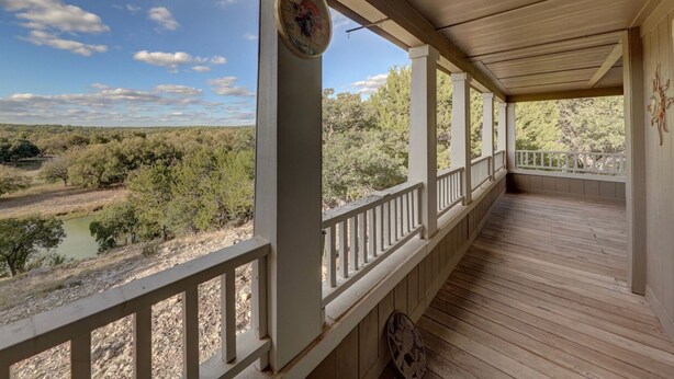 A covered porch with a view of a river and trees. - Secluded & Spacious River Retreat With A View  (Roosevelt)