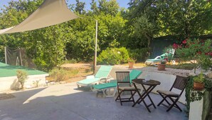 A patio area with lounge chairs, a small table, and a shade sail. - Nice apartment in Labin with WiFi (Labin)