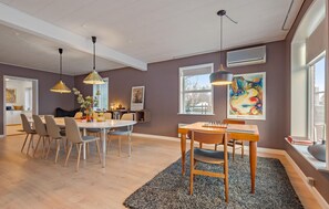 A modern dining area with a round table, chairs, and a chessboard. There are two pendant lights, a large window, and artwork on the walls. - Nice home in Bredebro with WiFi (Bredebro)