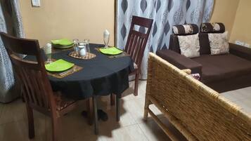 A dining area with a round table, chairs, and a sofa.