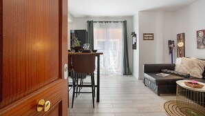 Una sala moderna con un sofá, una mesa de centro y un comedor con mesa y sillas.