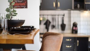 Una cocina con una mesa de comedor, sillas, un tazón negro y una planta en maceta.