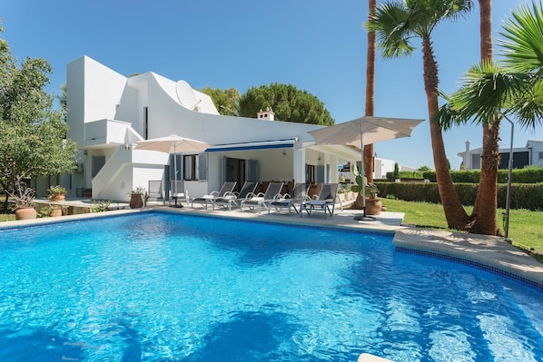 A modern villa with a swimming pool, lounge chairs, and palm trees. - Villa "Playa" with Mountain View, Private Pool & Wi-Fi (Pollensa)