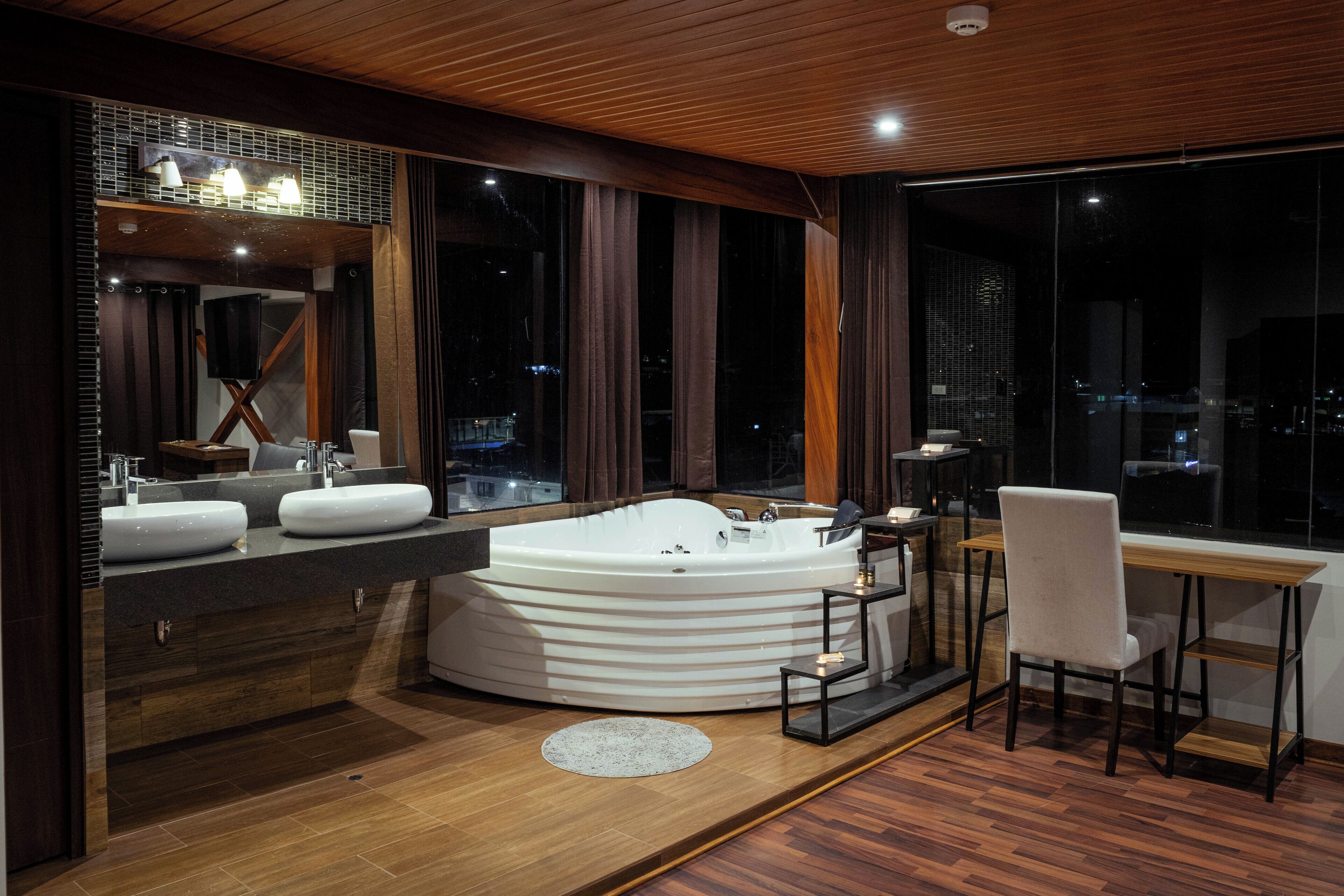 Une salle de bain moderne dotée d’une grande baignoire, de deux vasques et d’un meuble-lavabo.