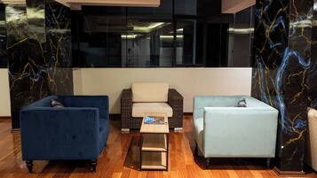 A modern lobby with a blue sofa, a light blue sofa, and a small table with a book.