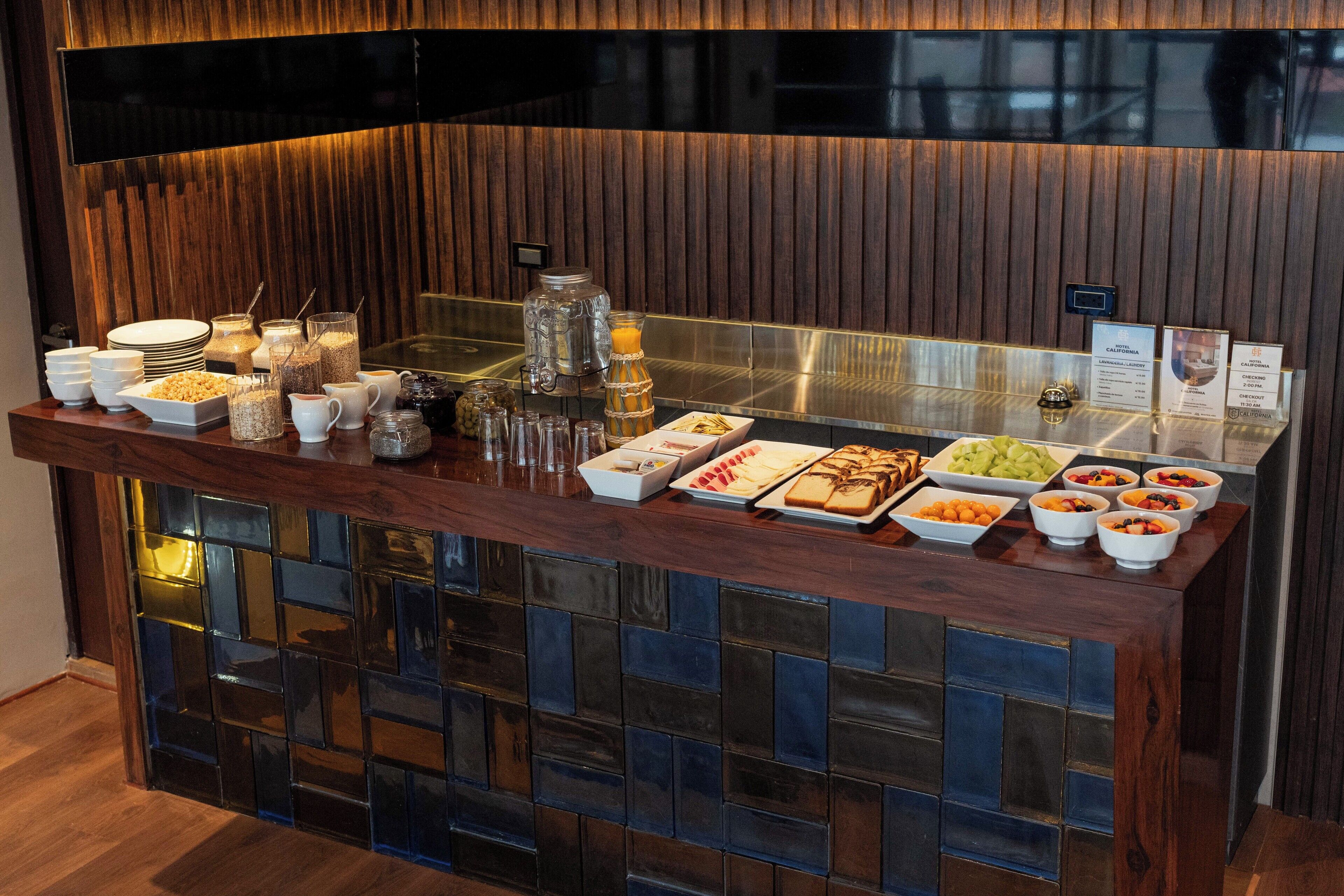 Una mesa de buffet con diversos alimentos y bebidas.
