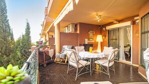 Ein Balkon mit Sitzgelegenheit im Freien, einem Tisch mit Lampe und Blick aufs Meer.