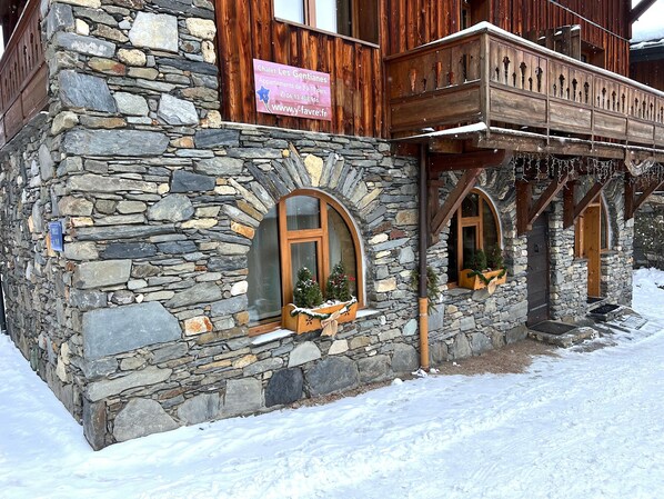 Un edificio in pietra con balconi in legno e finestre ad arco.
