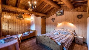 Une pièce aménagée comme un chalet en bois, avec un lit, une petite table et une table de chevet.