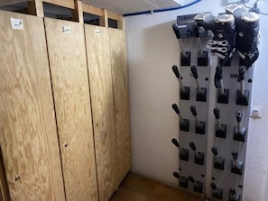 Una habitación con armarios de madera, un equipo de aire acondicionado montado en la pared y un perchero con varios pomos negros.
