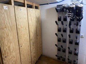 Une pièce avec des armoires en bois, un climatiseur fixé au mur et un porte-serviettes avec plusieurs barres noires.