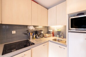A kitchen with a built-in stove, a microwave, a sink, and a coffee maker.