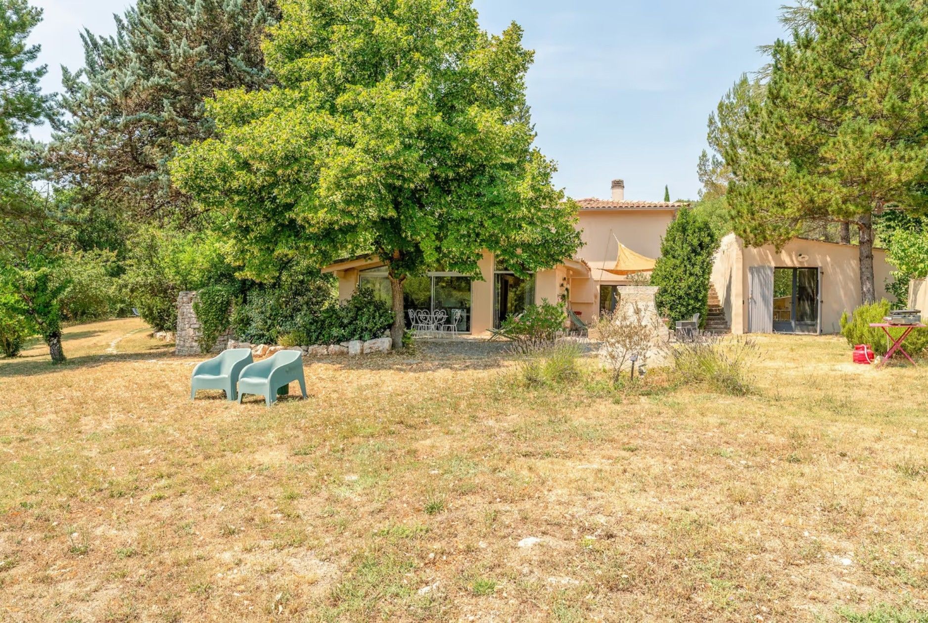 A property with a patio area, outdoor seating, and a building with a tiled roof.