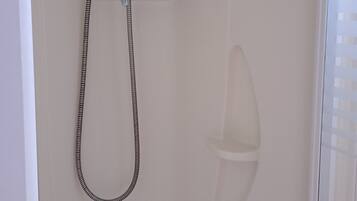 Ducha con manguera, desagüe y panel de control en la pared.