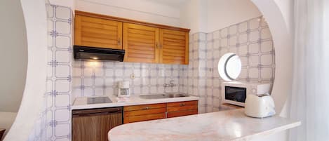 Een koelkast, een magnetron, een kookplaat, een vaatwasser