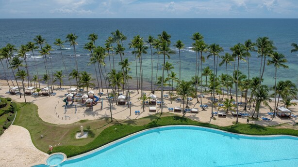 Un resort con piscina, playa y vista al océano.