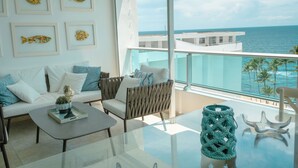 Una sala de estar moderna con una mesa de vidrio, un sofá y un balcón con vistas al mar.