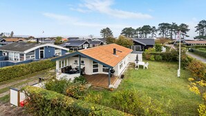 Een woonwijk met meerdere huizen, een gazon en een klein terras met tuinmeubilair.