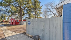 A gated area with a blue building, a red house, and a stop sign.