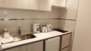 A compact kitchen with a stainless steel sink, a coffee maker, a toaster, and a dishwasher. - Luxury and Comfort in San Telmo - Your Exclusive Retreat Num4915 (Buenos Aires)