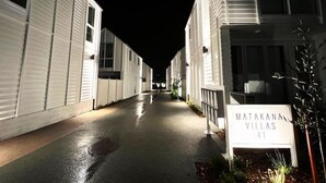 Una hilera de villas blancas con un letrero que dice 'MATAKANA VILLAS 41' al final.