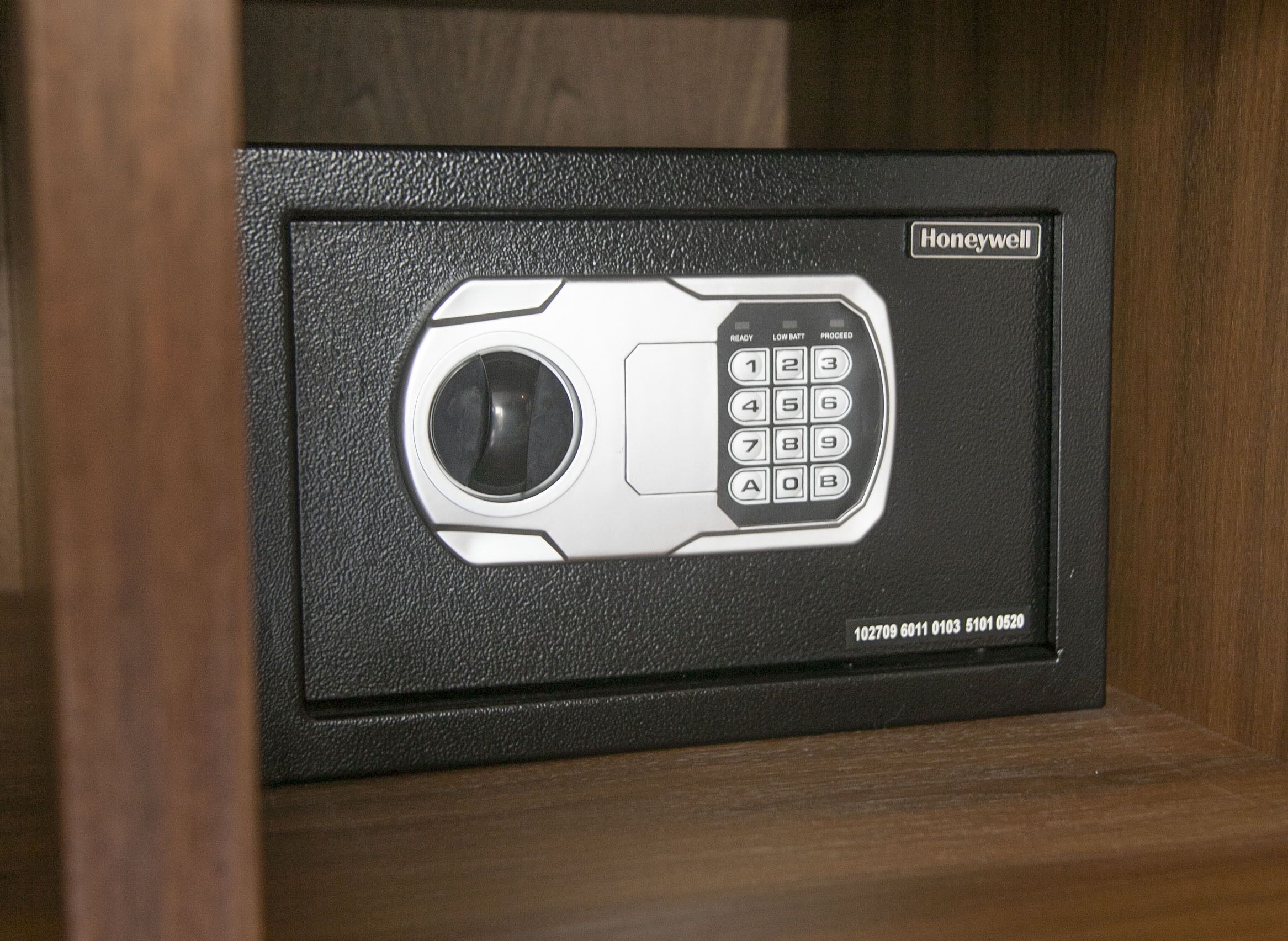 Un coffre-fort Honeywell doté d’un clavier et d’une fenêtre de visualisation, placé dans un meuble en bois.