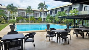 A poolside area with outdoor seating and a view of a swimming pool. - Bohol Jewel Resort (Dauis)