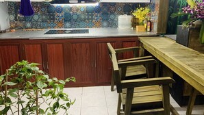 Una cocina con armarios de madera, salpicadero de azulejos y una barra de bar de madera.