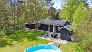 A house with a swimming pool, a patio with outdoor furniture, and a forested area. - "Esmer" - 8km from the sea by Interhome (Ebeltoft)