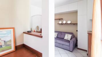 A room with a wooden desk, a framed picture, and a mirror on the wall.