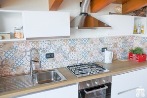 Cafetera o tetera, frigorífico, horno y placa de cocina