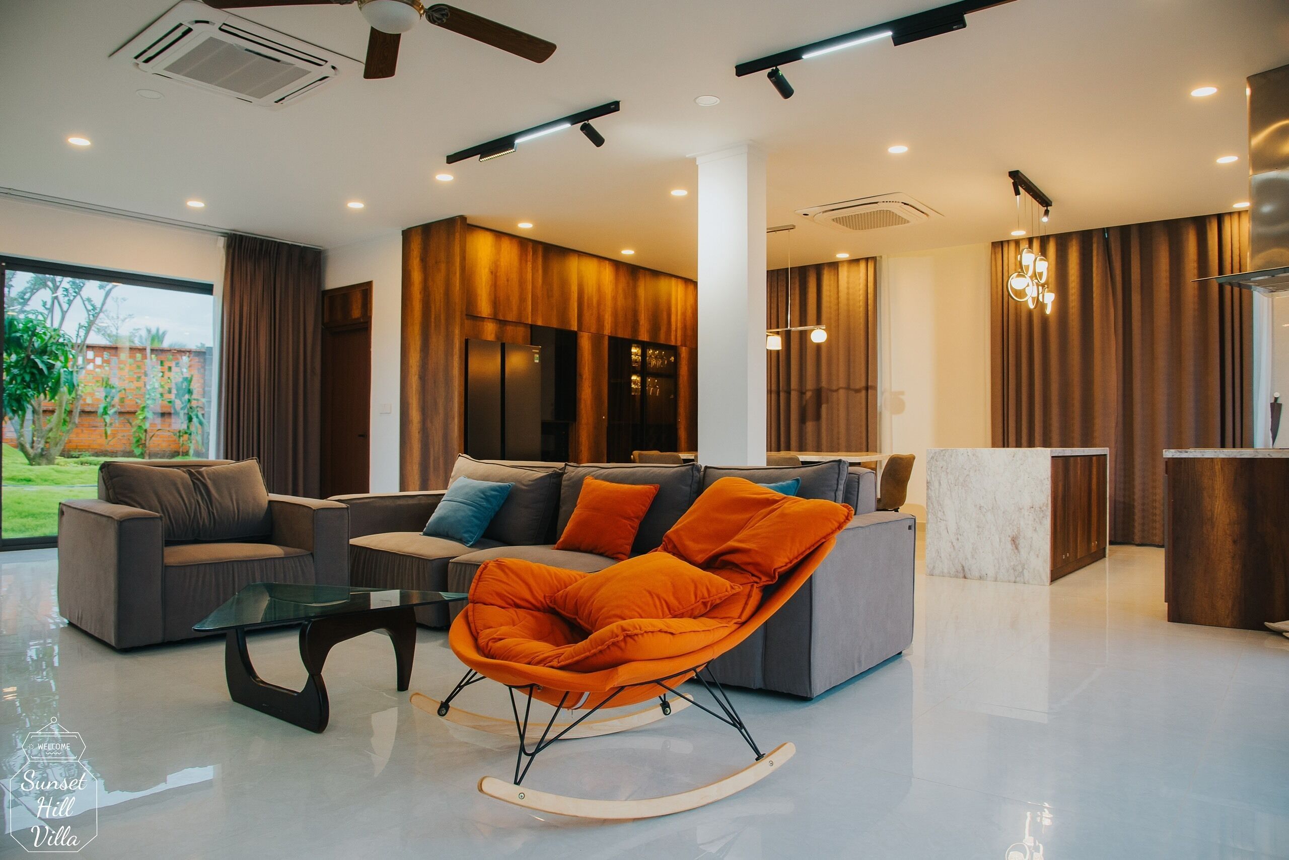A modern living room with a sofa, a rocking chair, and a coffee table.